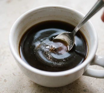 Das Pulver wird im Kaffee eingerührt